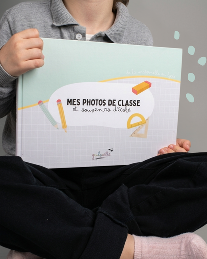 Enfant tenant l'album Mes photos de classe & souvenirs d'école