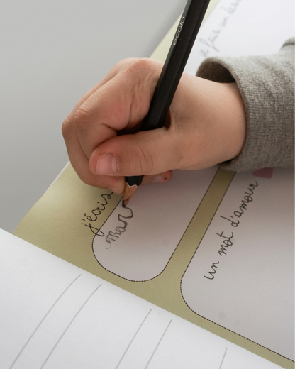 Enfant qui écrit dans l'album souvenirs d'école